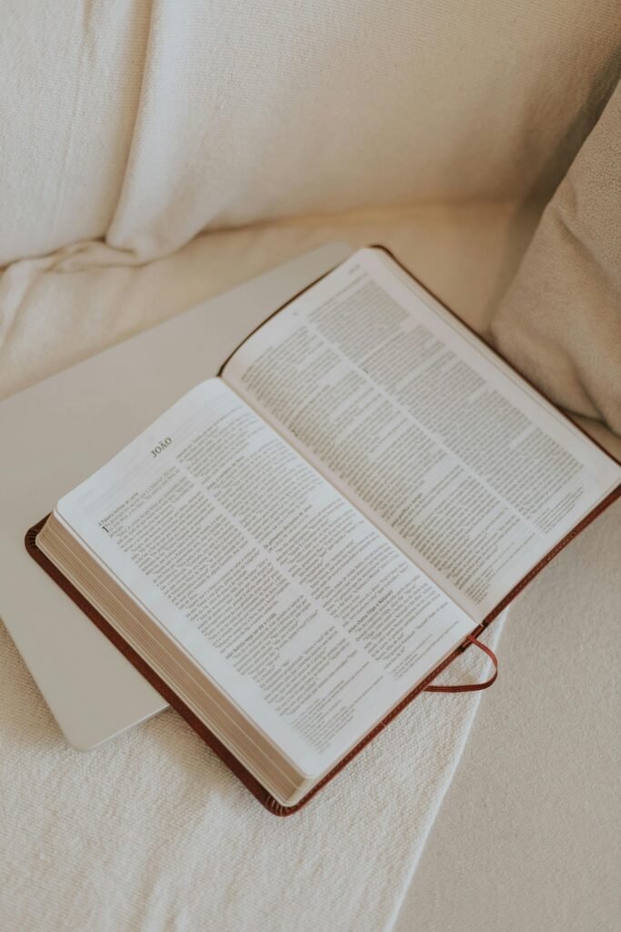 An open Bible resting on a cozy couch, ideal for study and reflection.