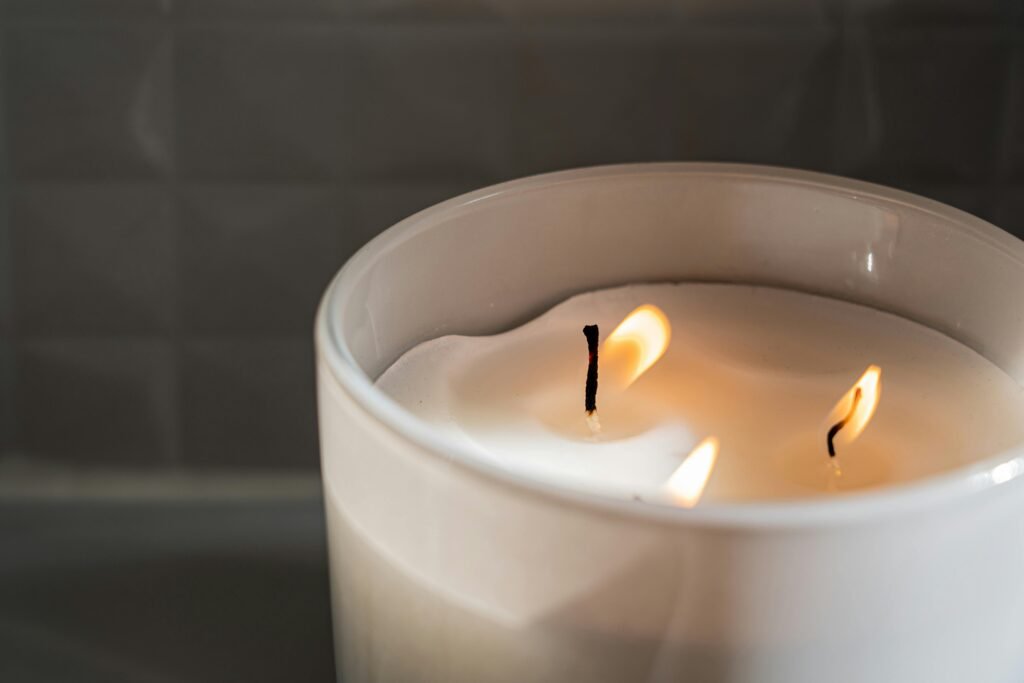 A close-up of a lit candle in a ceramic jar, creating a cozy atmosphere.