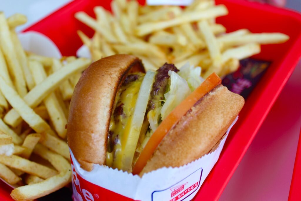 Savor a classic cheeseburger with fresh fries served in a vibrant red tray.